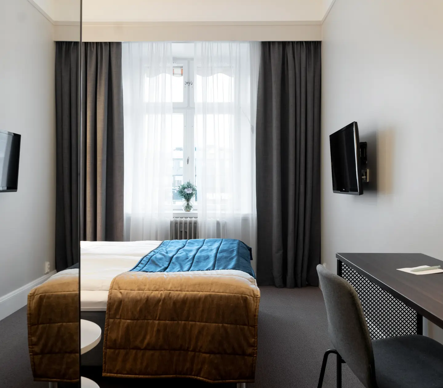 Hotel room with window, desk and TV