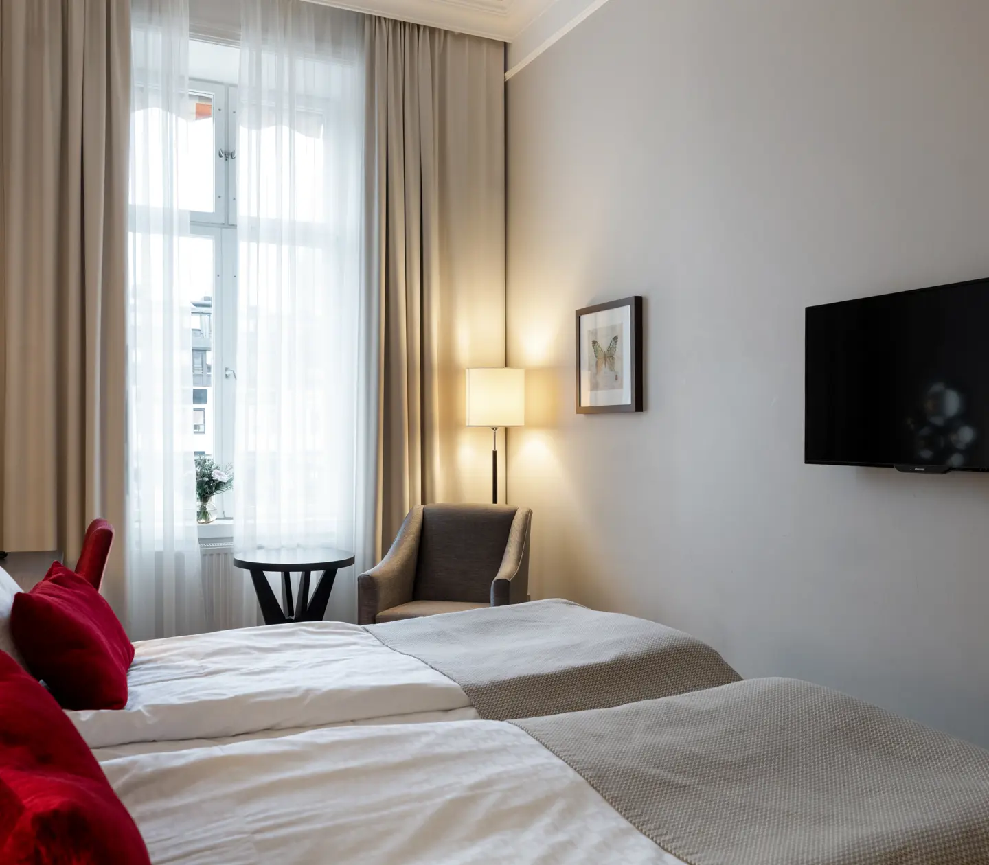 Hotel room with double bed, TV and armchair