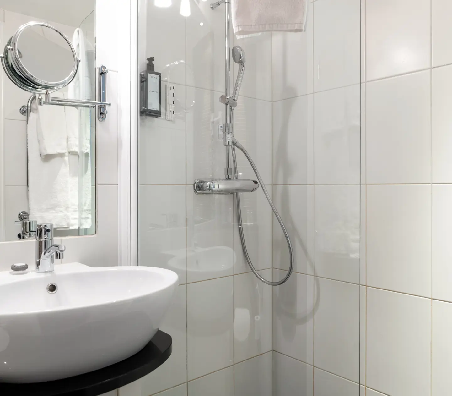 Bright bathroom with shower, sink and mirror