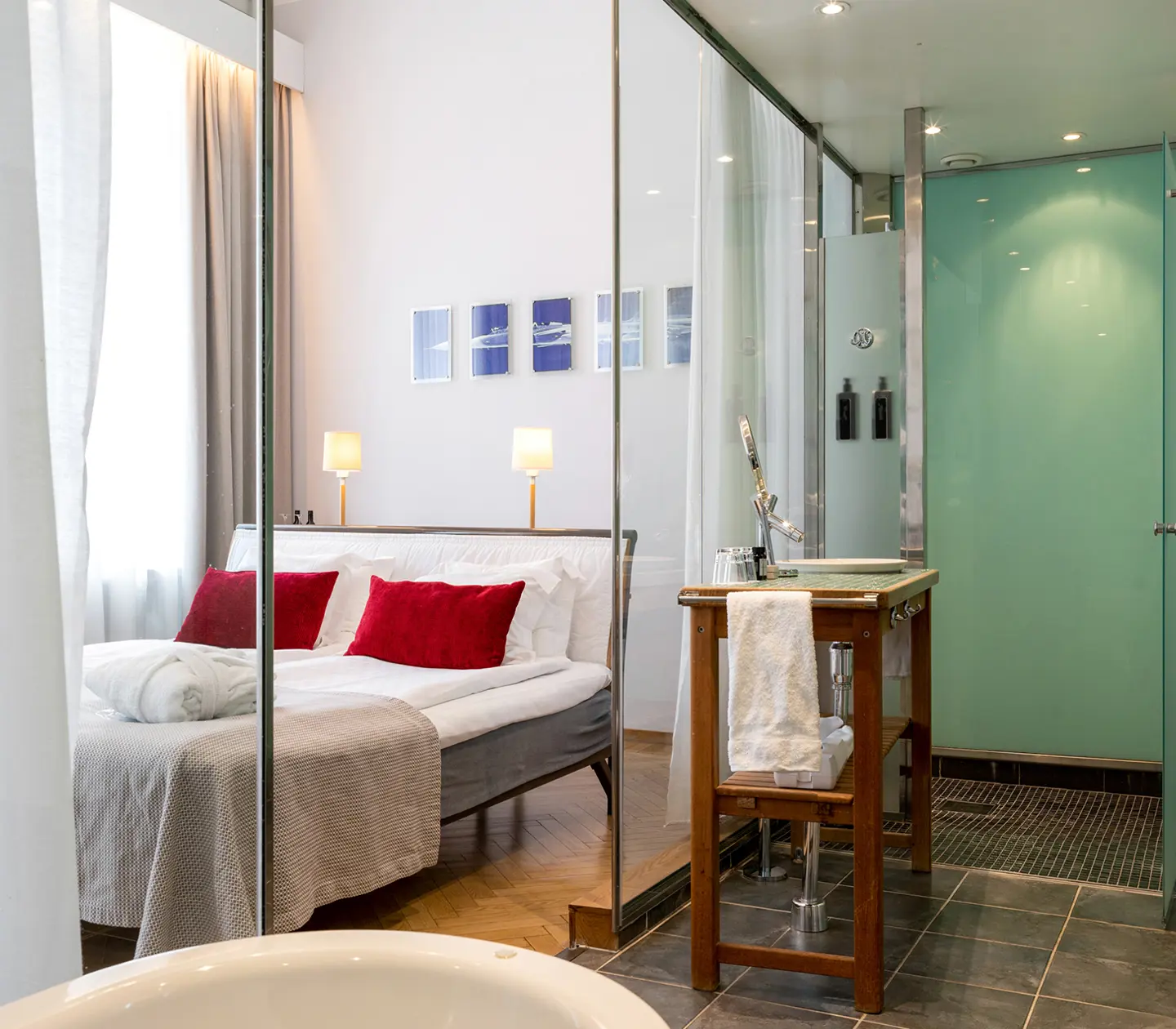 Bright hotel room with bathroom, glass wall and hotel room