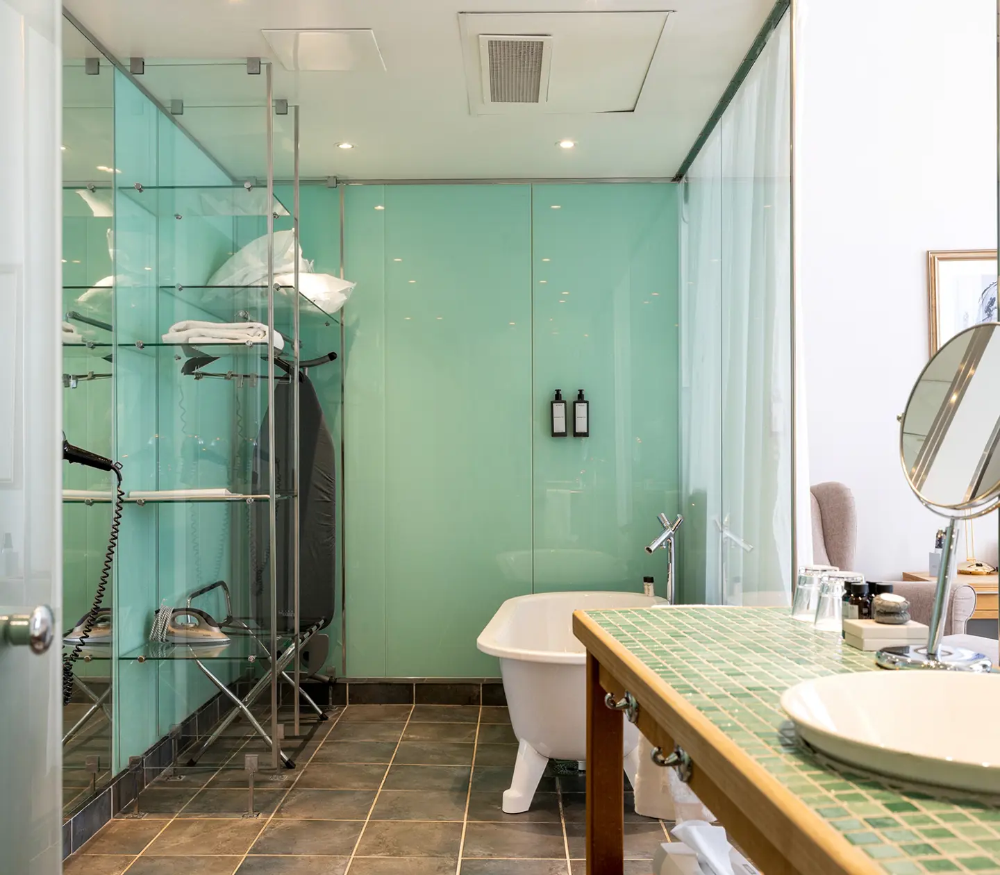 Bright bathroom with bathtub, wardrobe and sink