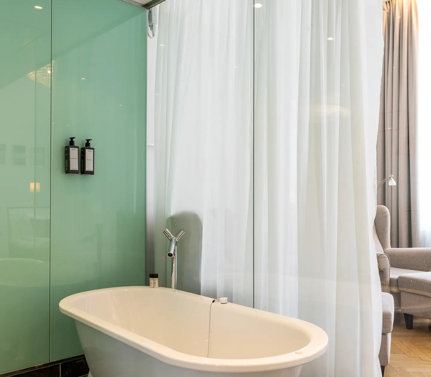 Bright bathroom with bathtub, soap and armchair