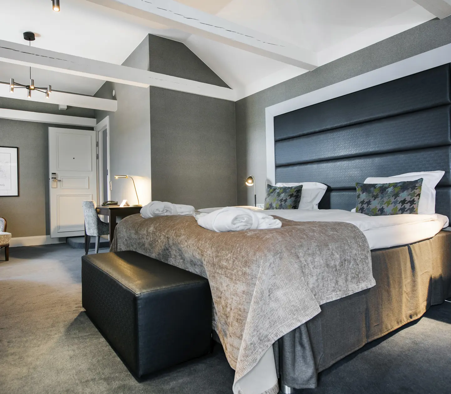 Dark suite with bed, armchairs and desk