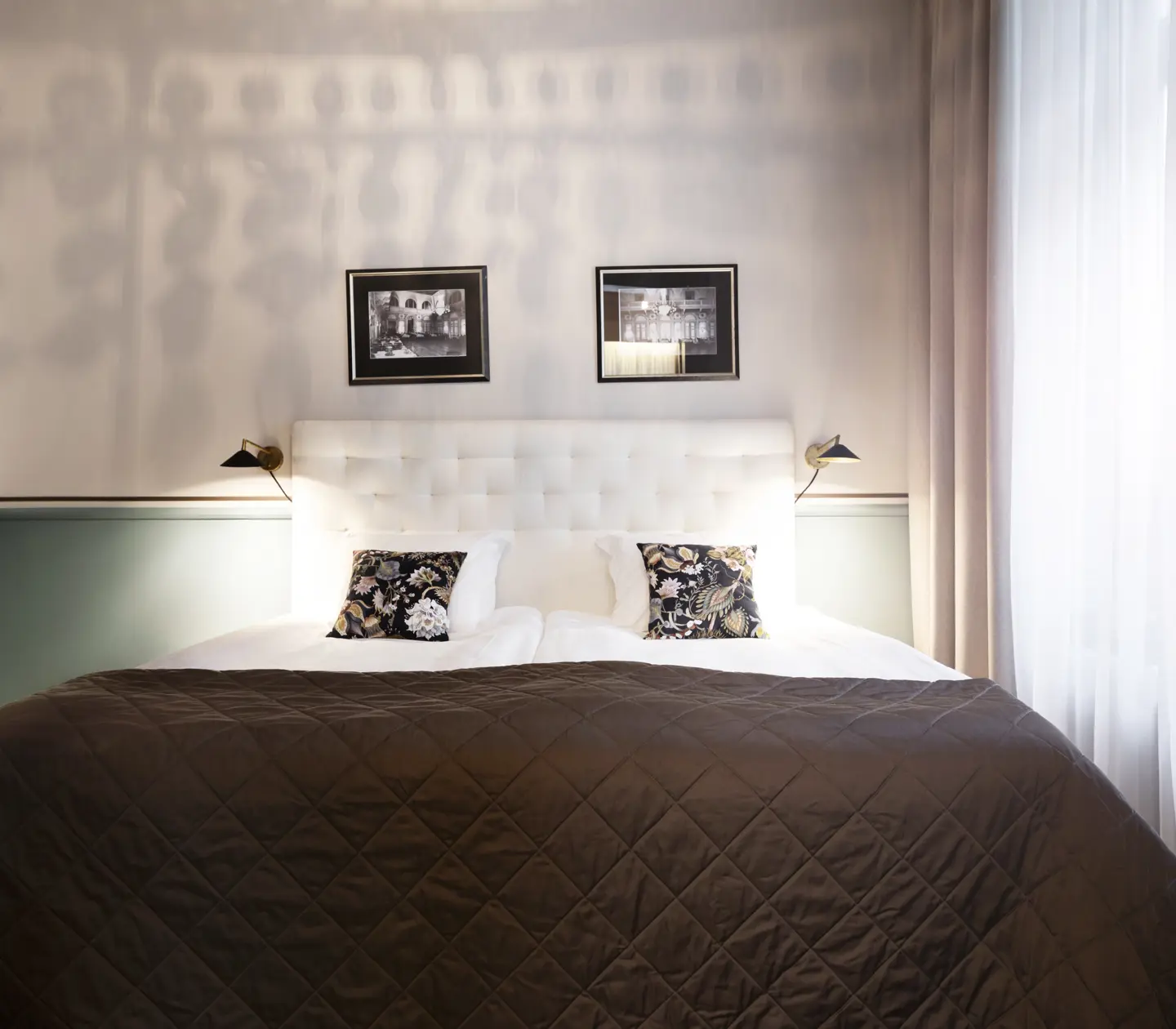Bright suite with double bed, green details and paintings
