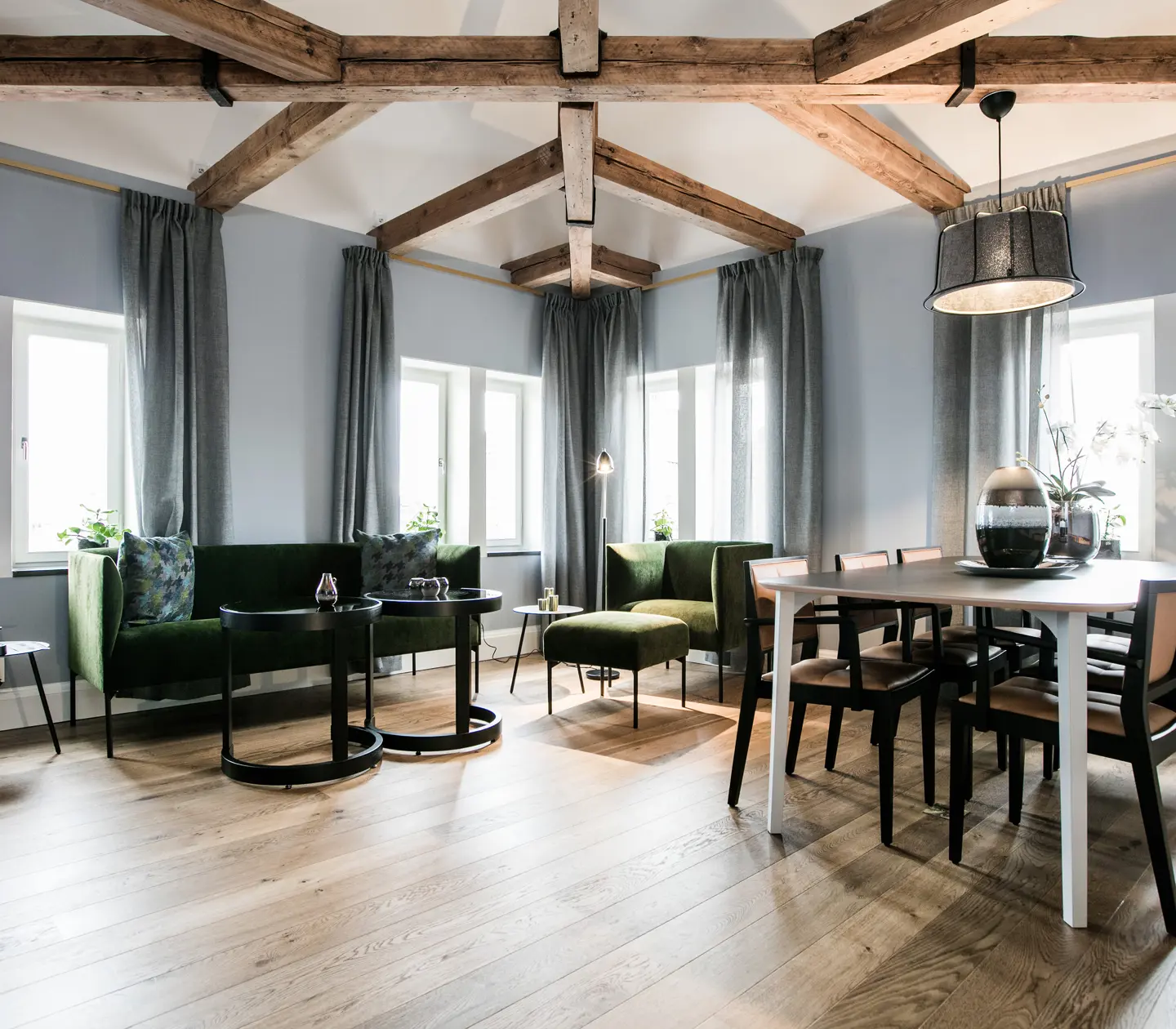 Cozy suite with dining table, sofa group and wooden beams in the ceiling