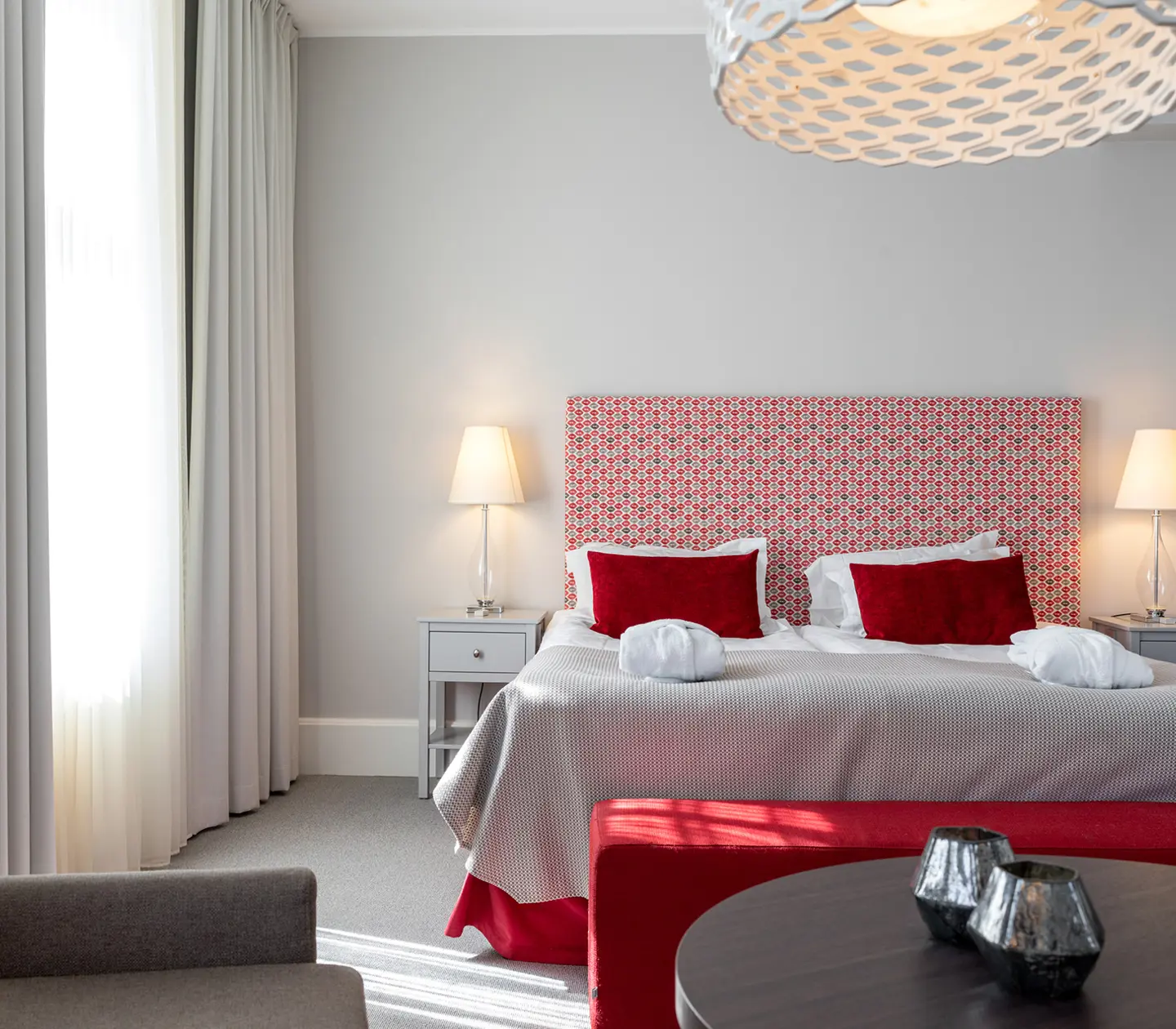 Bright suite with double bed, red textiles and windows