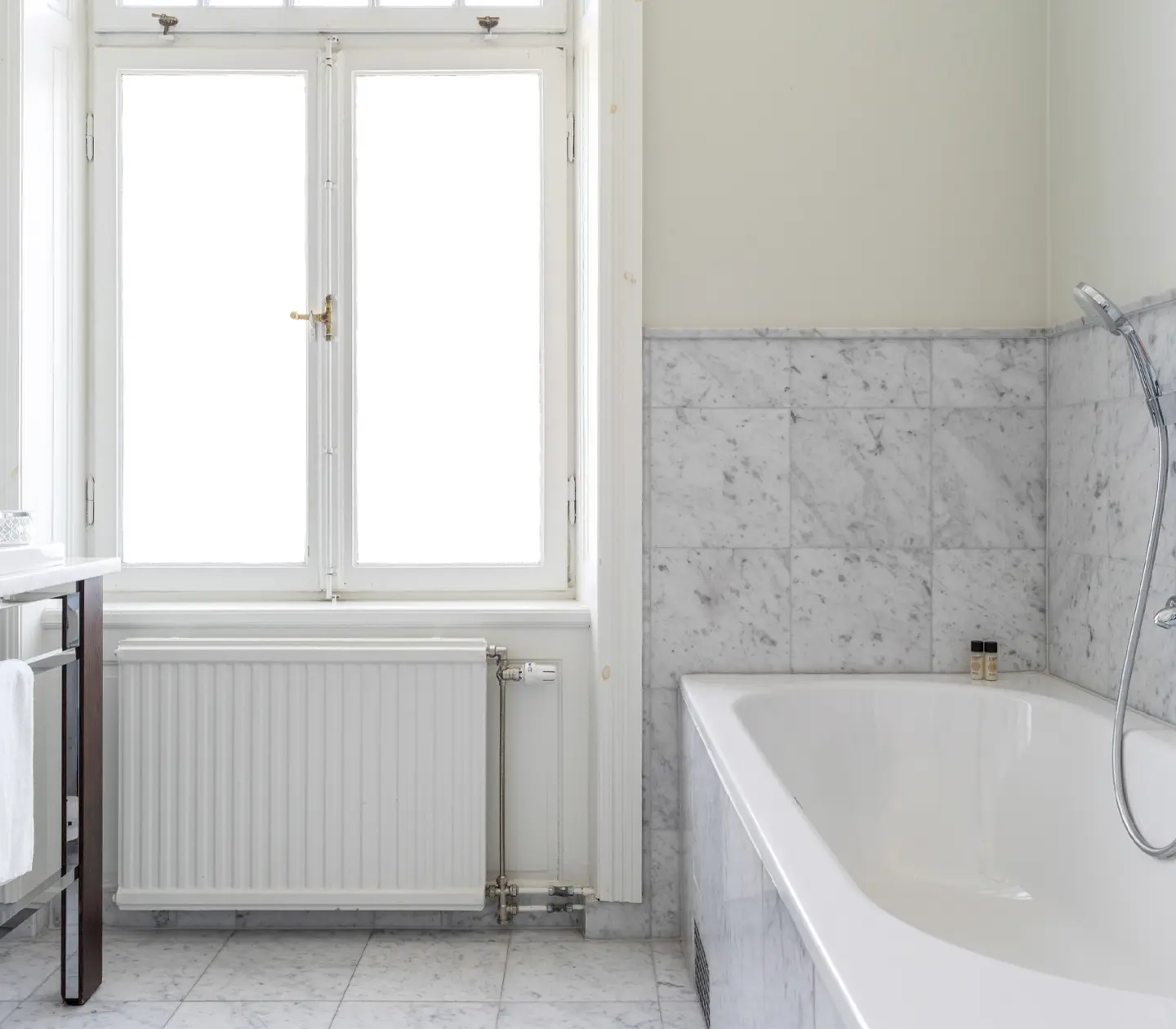 Bright bathroom with bathtub, sink and window