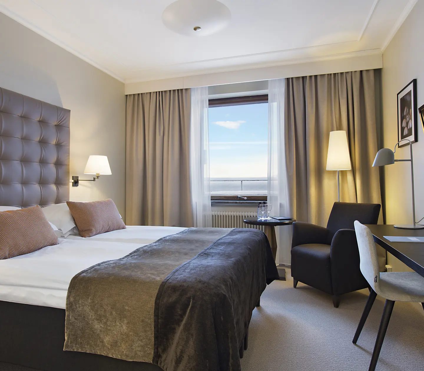 Hotel room with double bed, desk and window with sea view