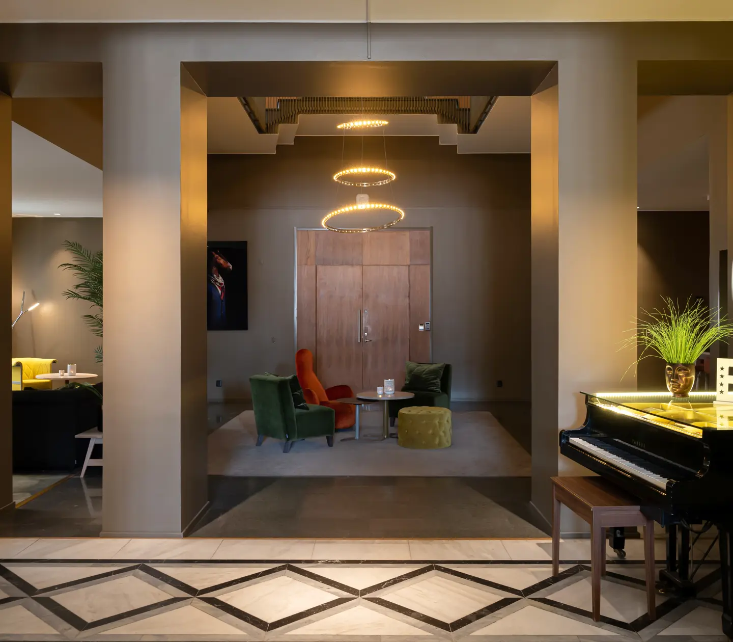 Hotel lobby with seating areas, piano and large lamp