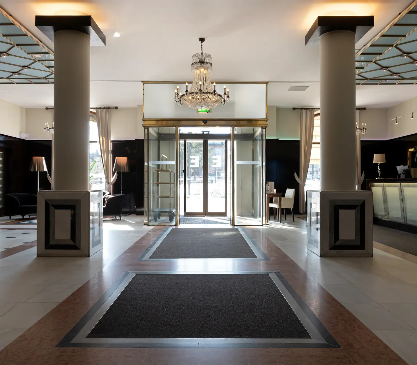 Hotel lobby with reception desk, crystal chandelier and pillars