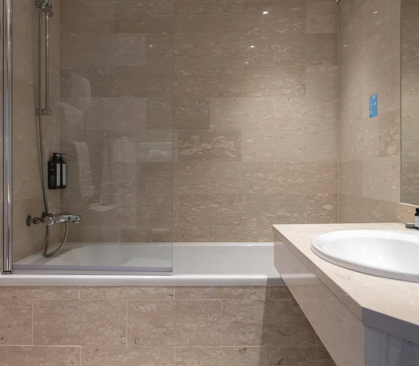 Beige bathroom with sink, bathtub and mirror