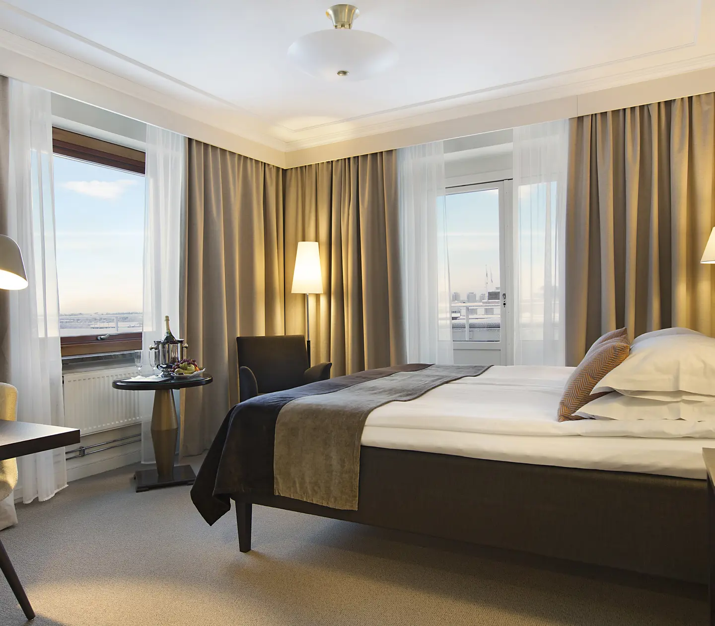 Bright hotel room with bed, armchair and window with sea view