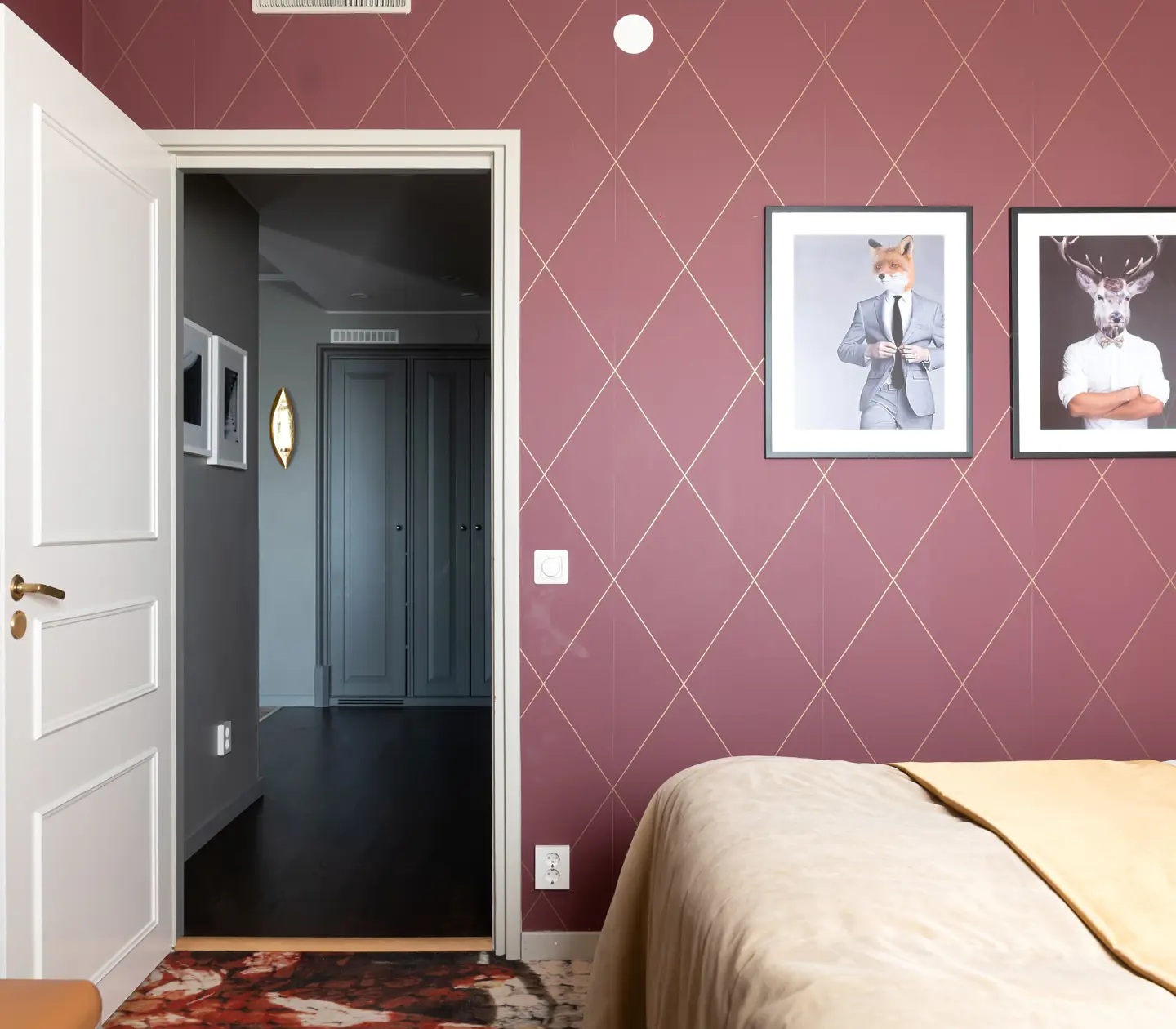 Suite with double bed, blackboard and burgundy wallpaper