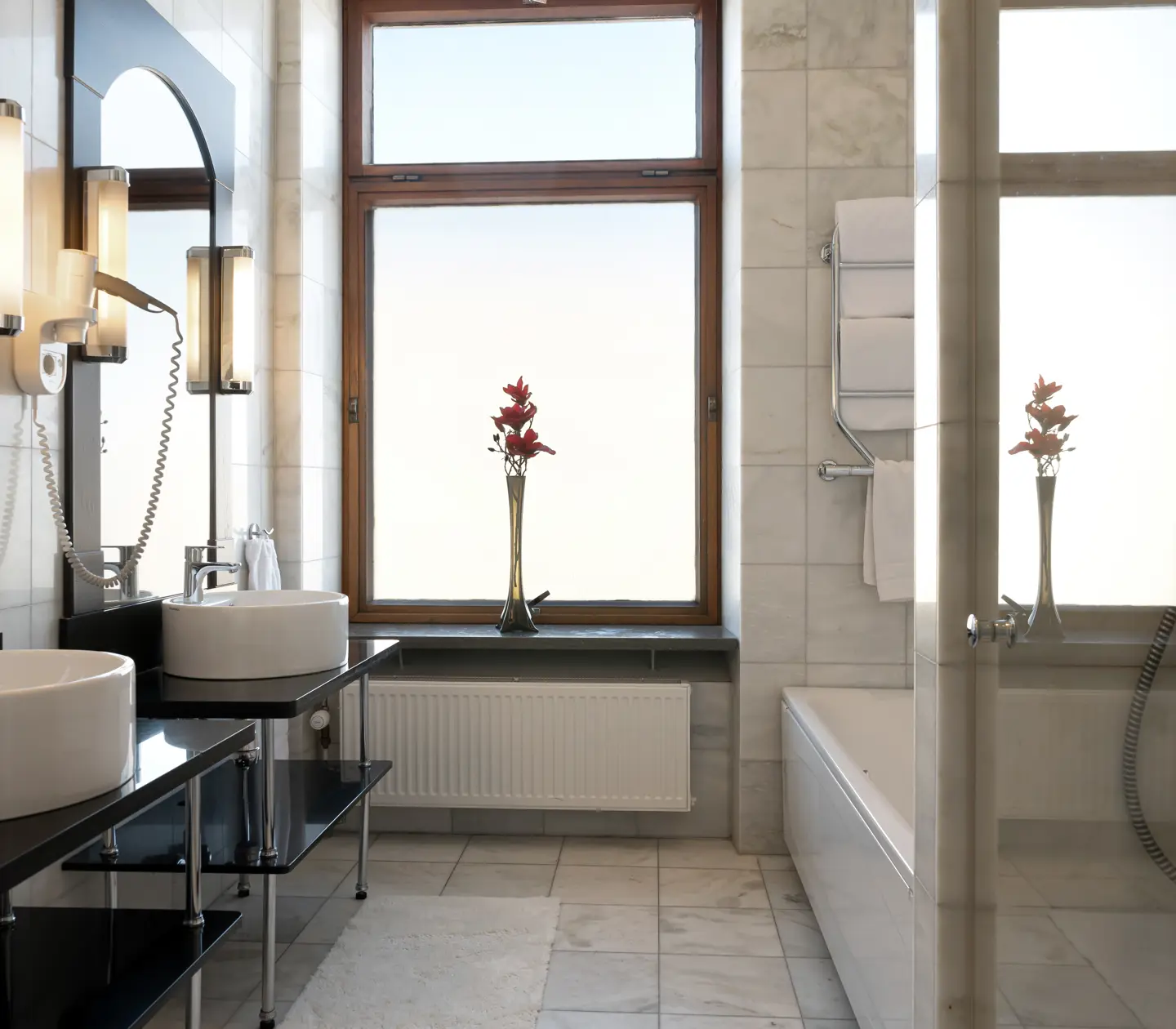Bright bathroom with double sinks, bathtub and window