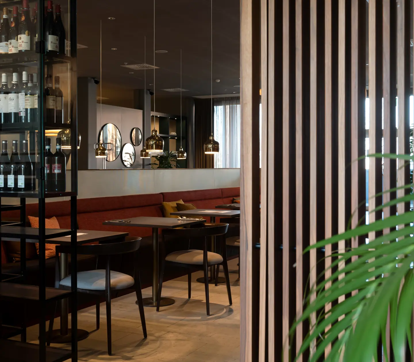 Restaurant environment with bottles, dining areas and mirrors