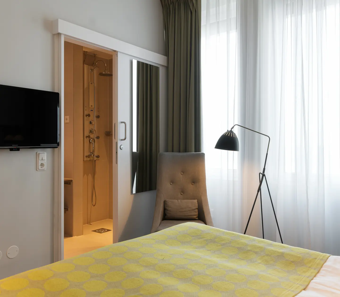 Hotel room with bed, armchair and TV