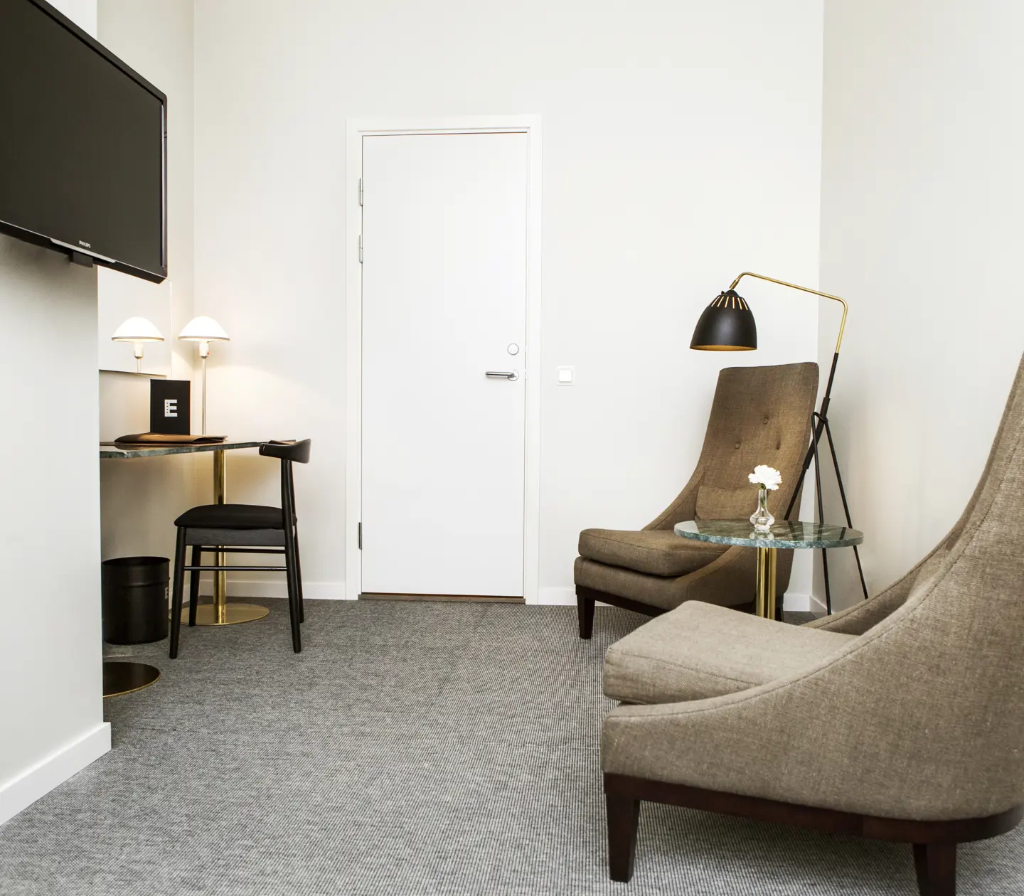 Hotel room with desk, armchairs and TV