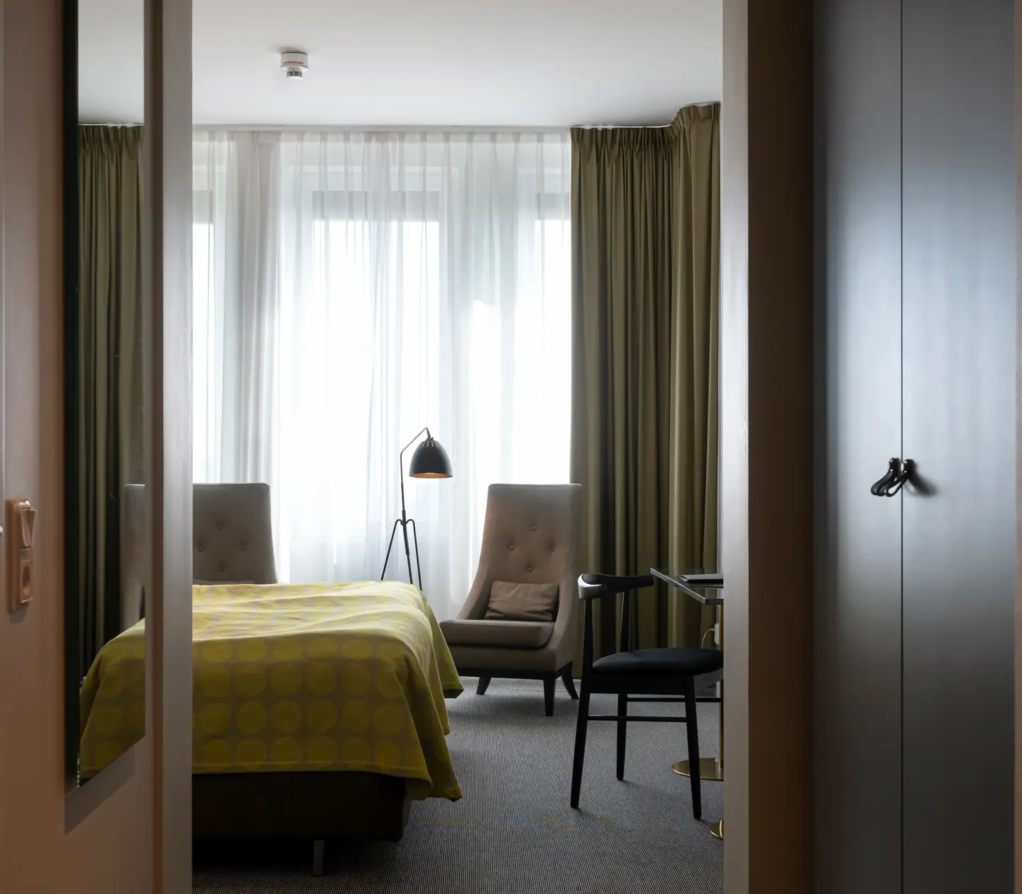 Hotel room with bed, armchair and window