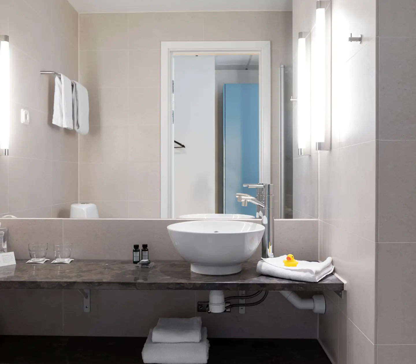 Beige bathroom with sink, mirror and towels