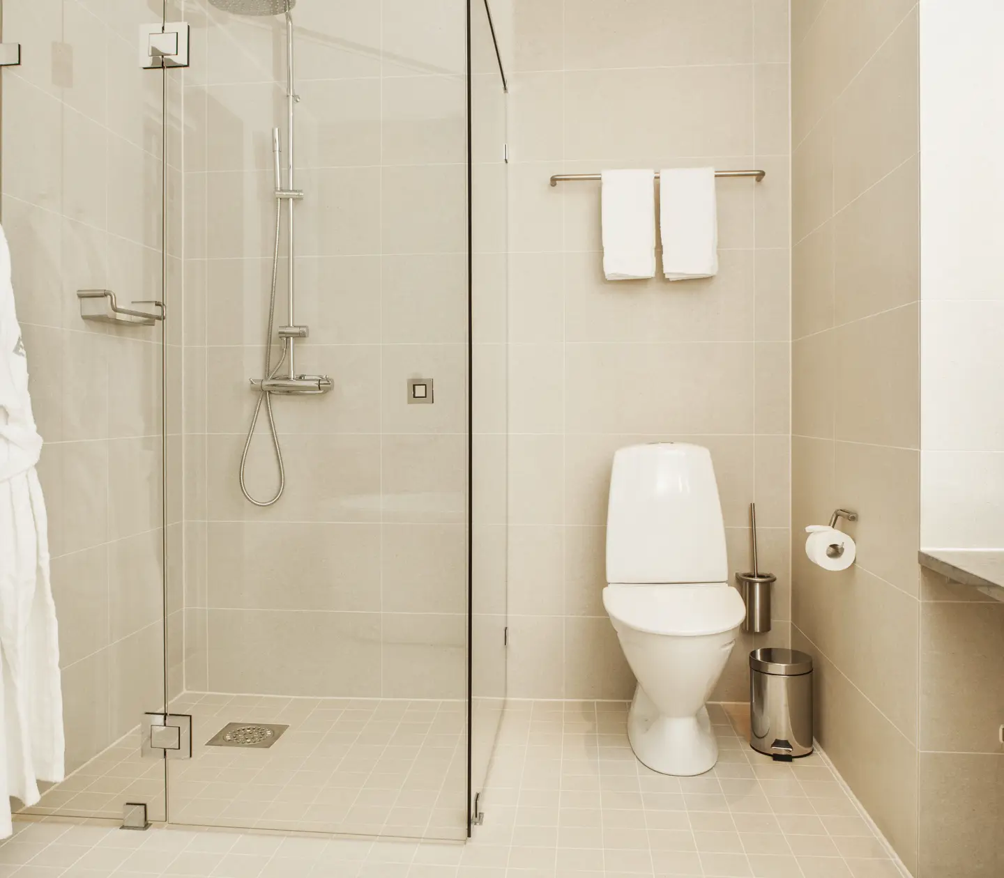 Bright bathroom with shower, toilet and bathrobes