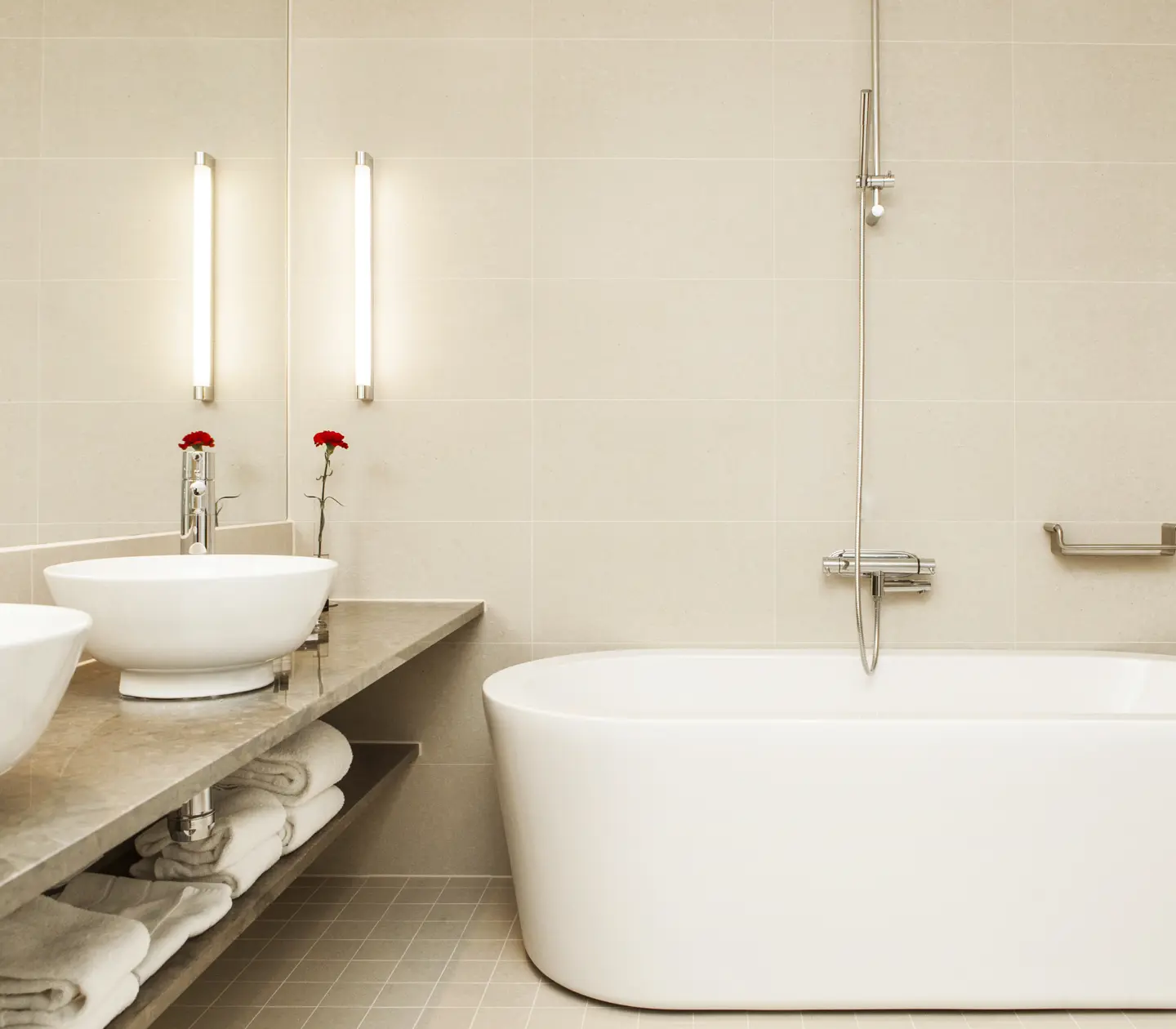 Bright bathroom with bathtub, double sink and towel