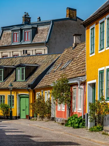 Charming cobblestone street with traditional colorful Swedish houses on a sunny day
