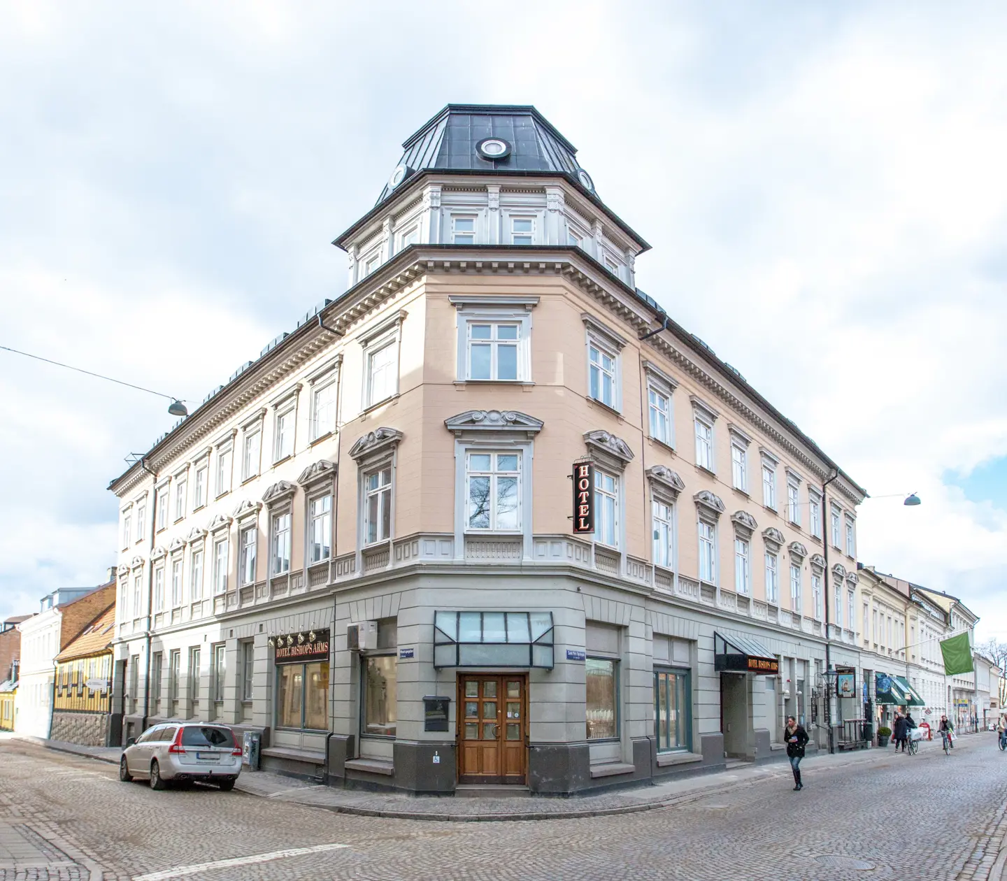 Facade of Hotel Bishops Arms with pedestrian street and cars in front