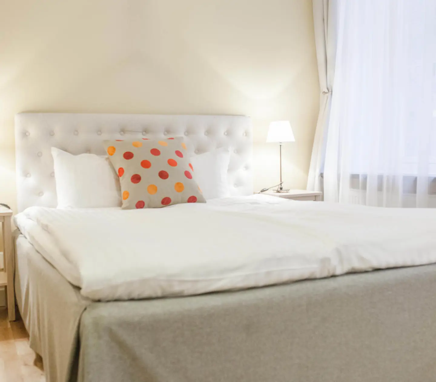 Bright hotel room with bed, window and bedside lamps