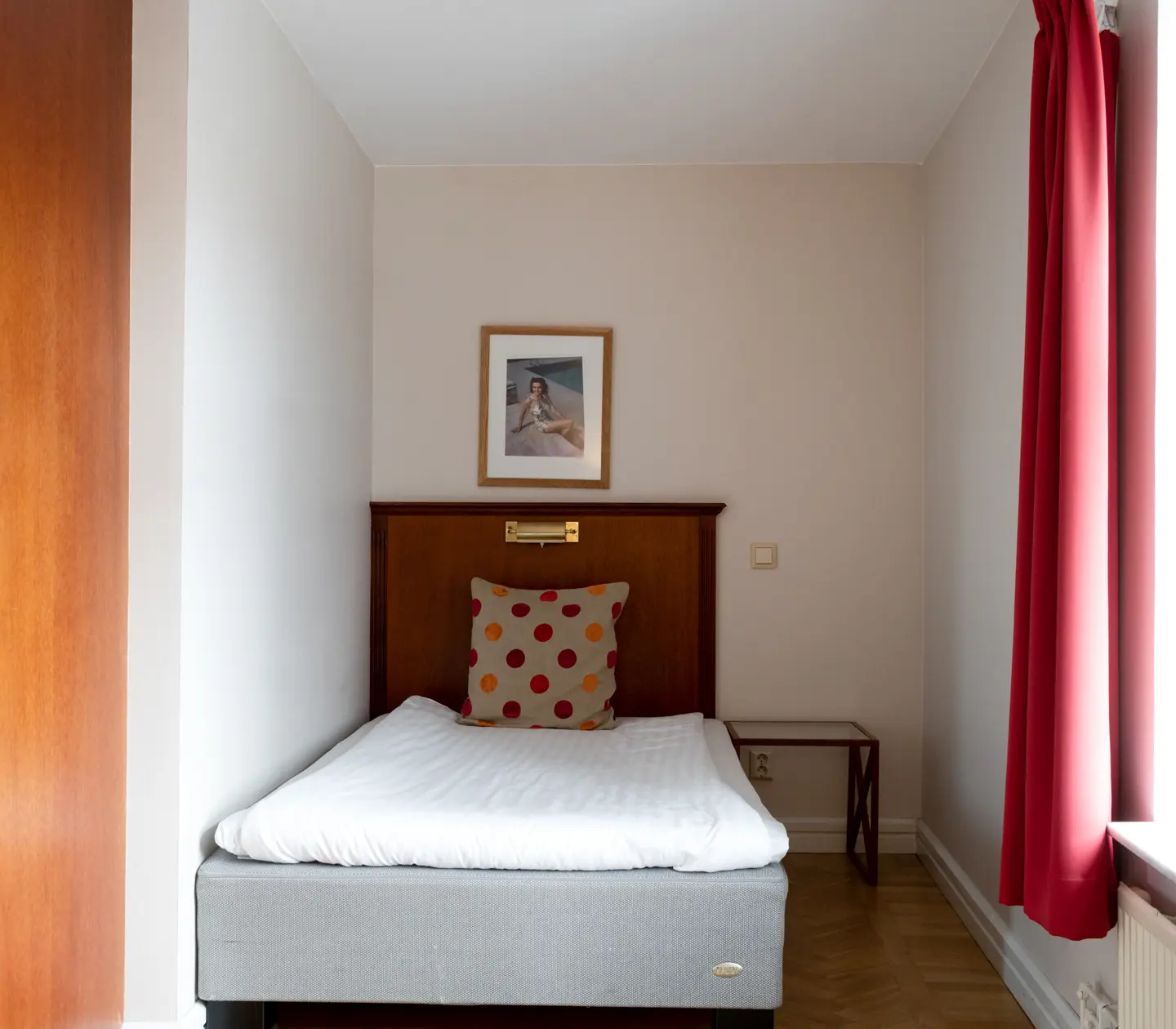 Hotel room with bed, wooden headboard and window