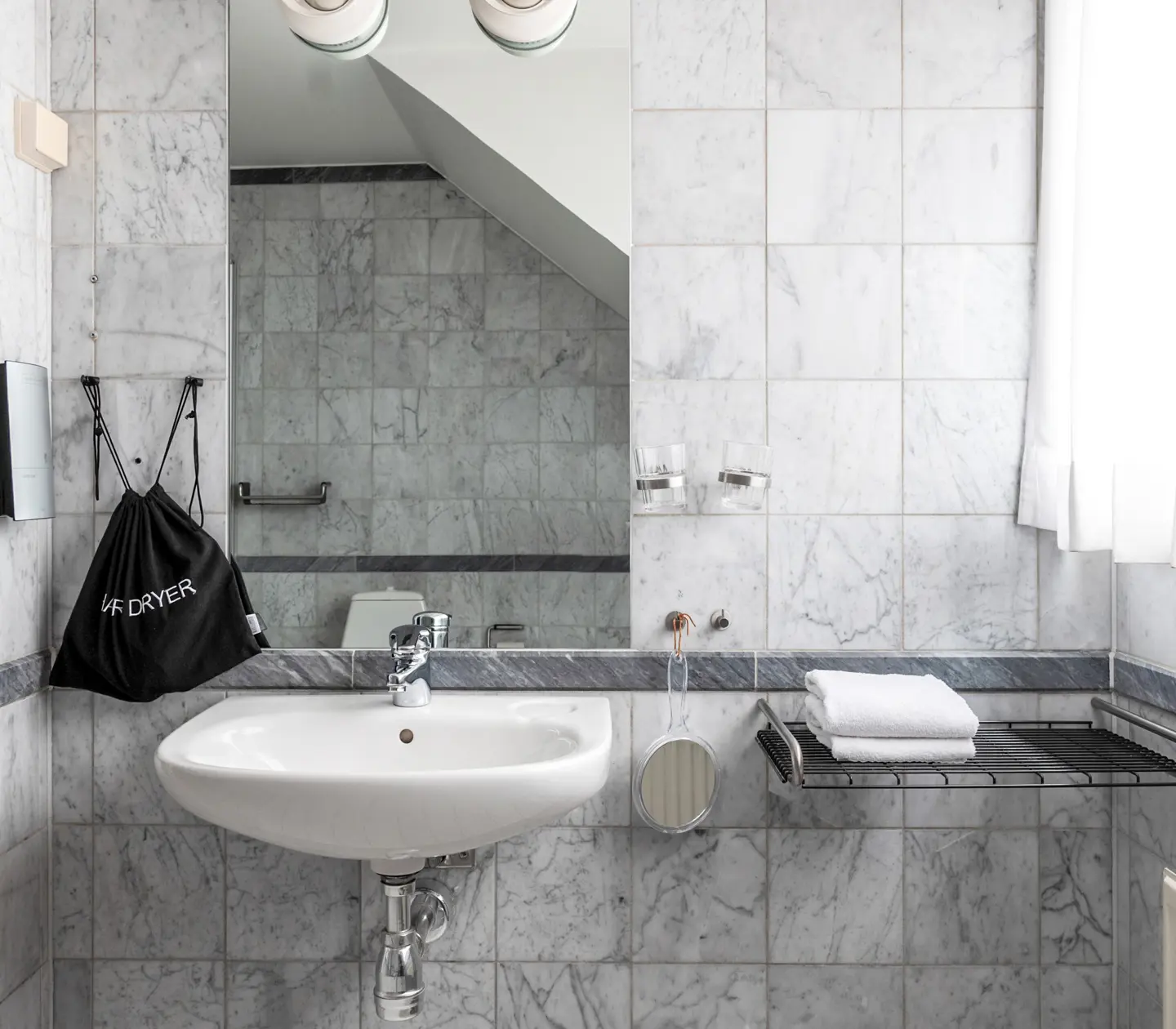 Bright marble bathroom with mirror, towels and sink