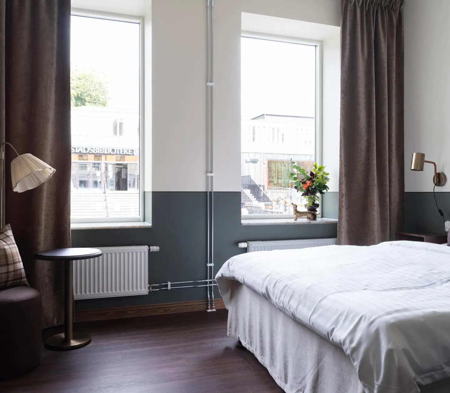 Mysigt hotellrum med säng, fönster och skrivbord