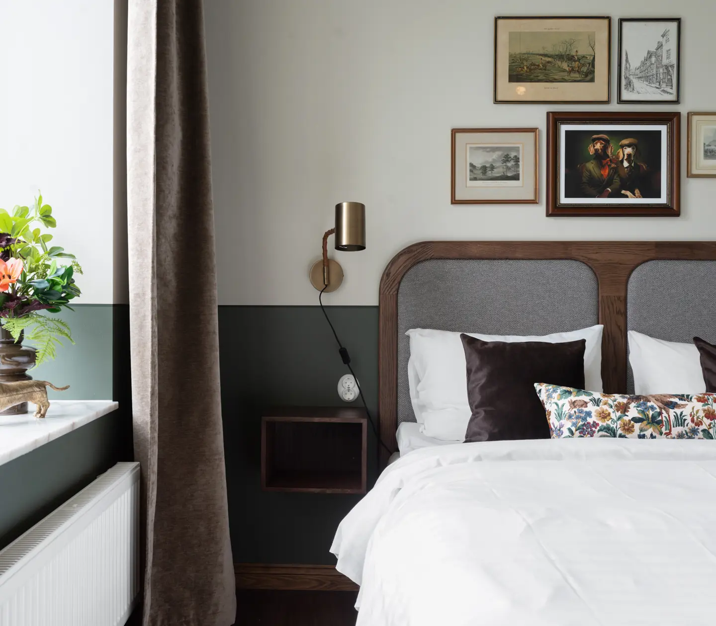 Hotellrum med säng, vit sänggavel och prickiga kuddar