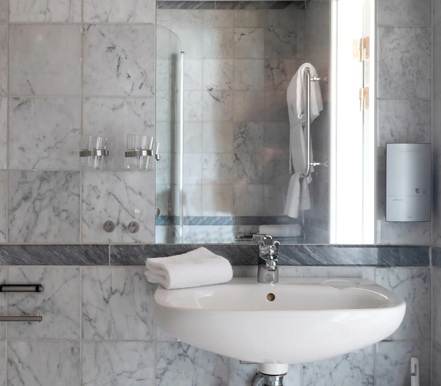 Bright marble bathroom with mirror, towels and sink