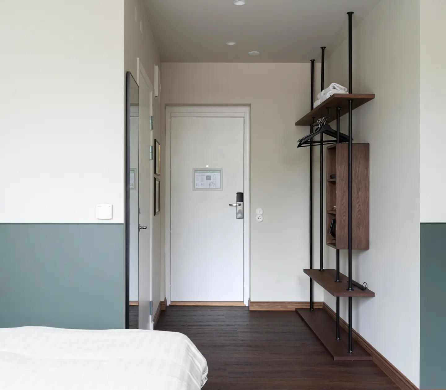 Mysigt hotellrum med säng, orange sänggavel och skrivbord