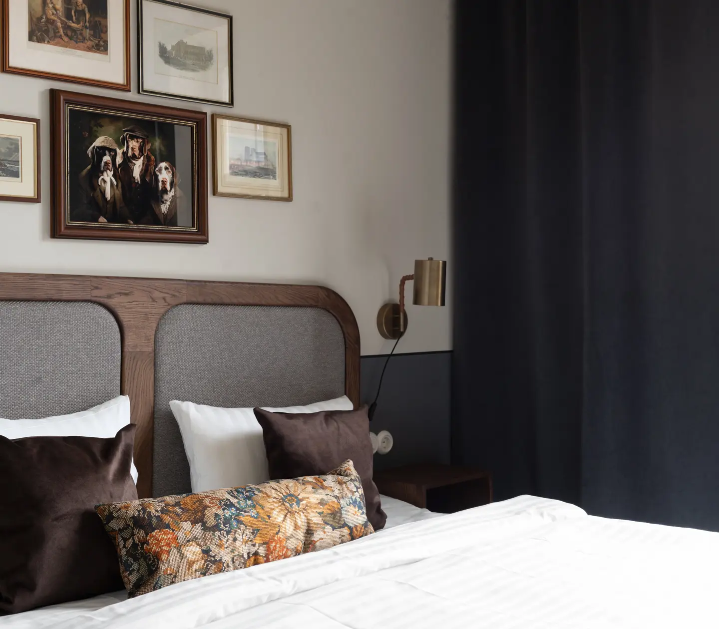 Hotellrum med säng, orange sänggavel och prickiga kuddar