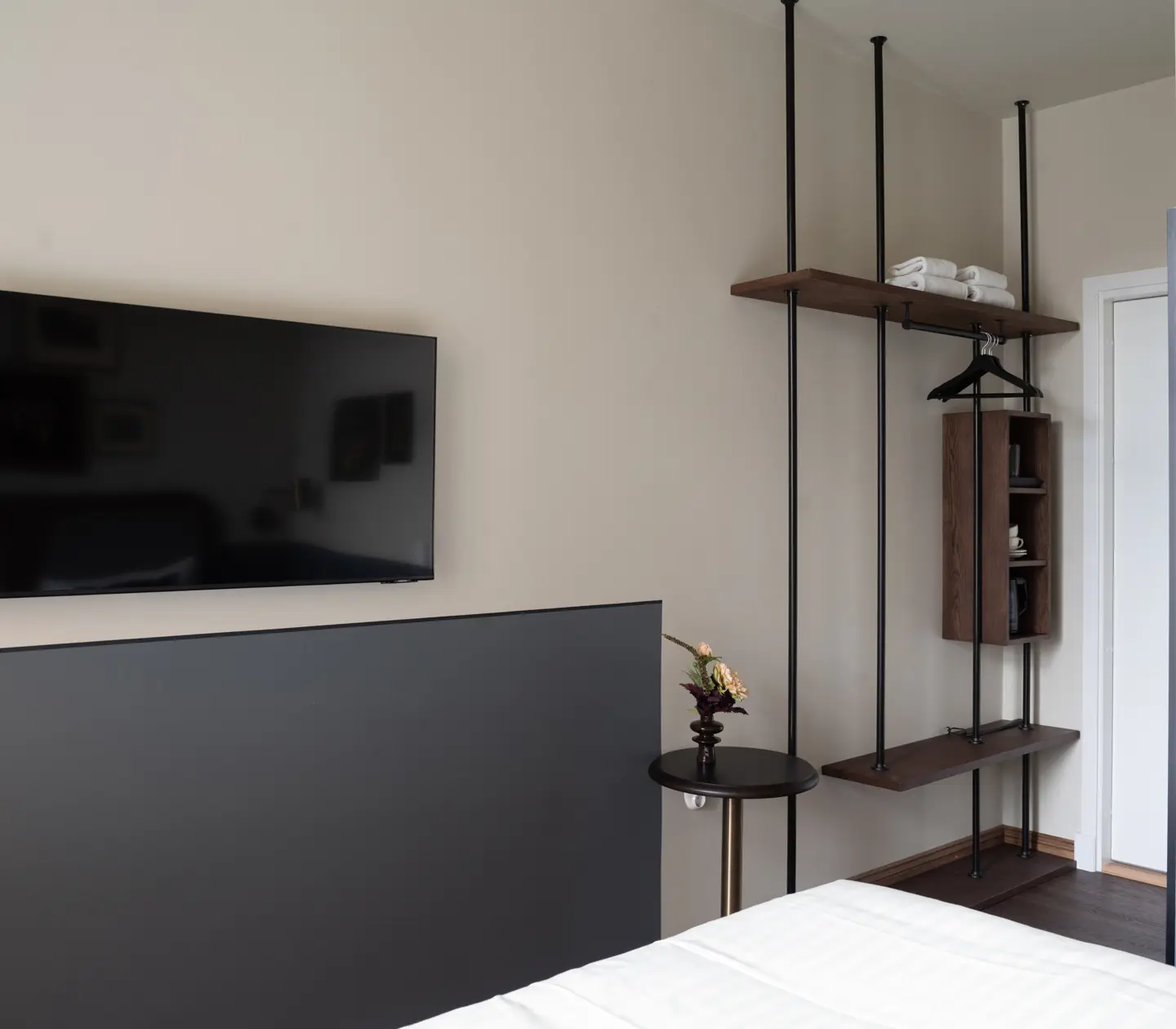 Hotellrum med säng, röd vägg och tavlor