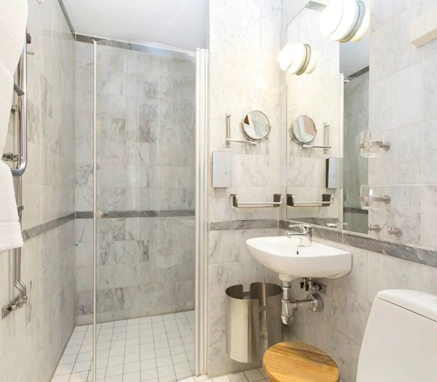 Bright marble bathroom with mirror, toilet and sink