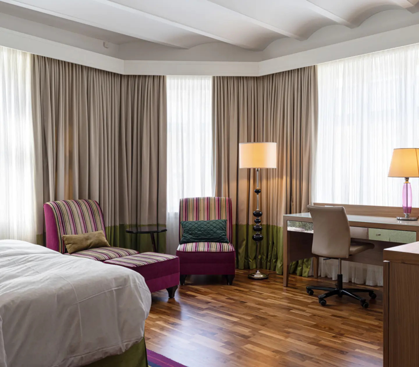 Hotellrum med tegelvägg, tv och fåtölj