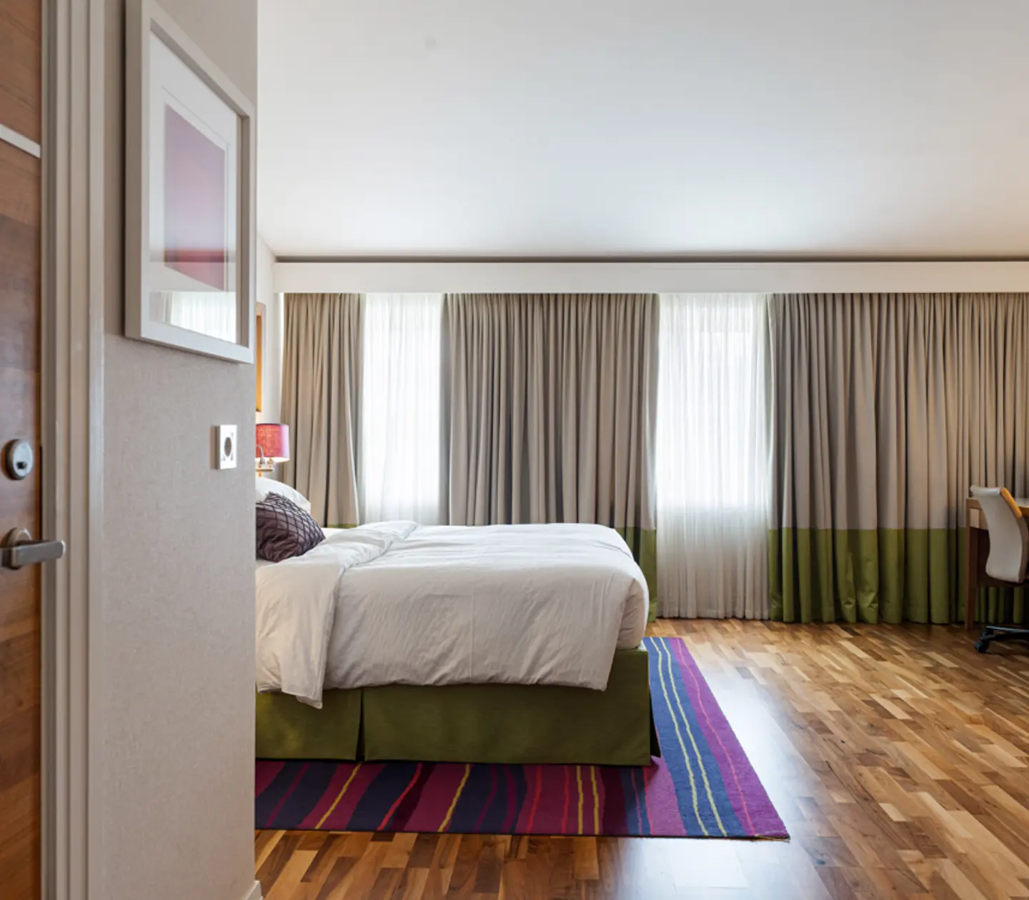 Hotellrum med tegelvägg, skrivbord och tv
