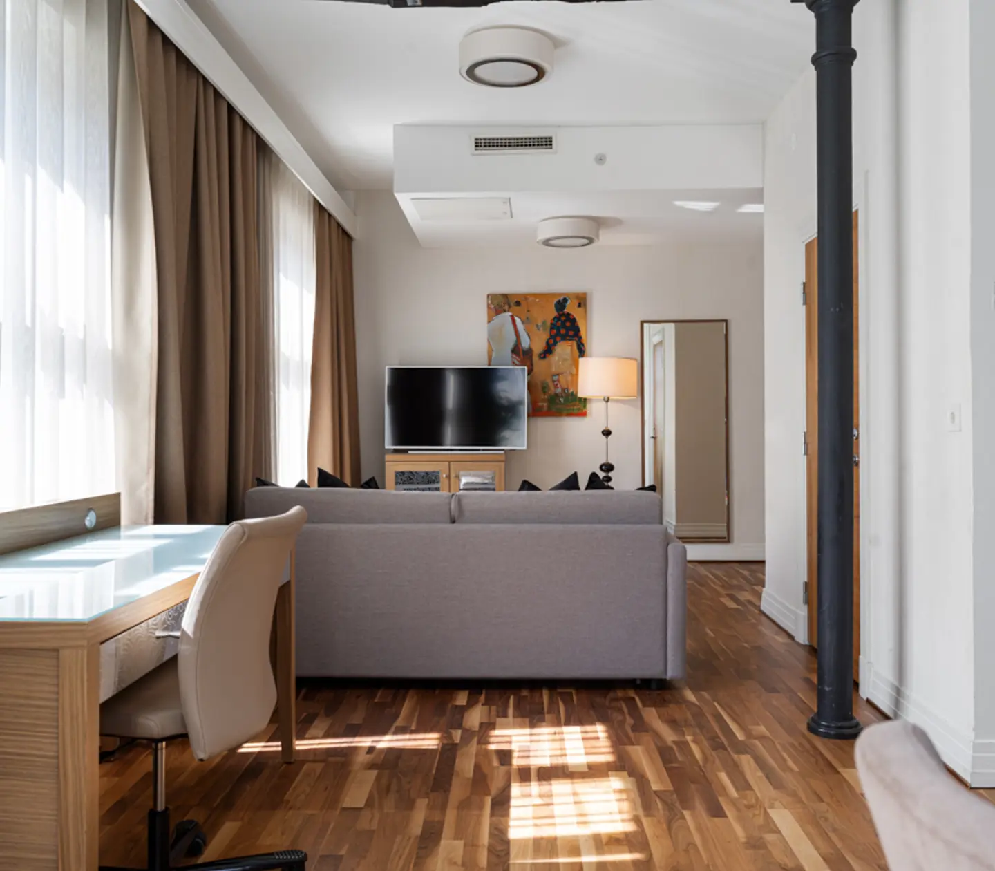 Svit med matbord, tv och stora fönster