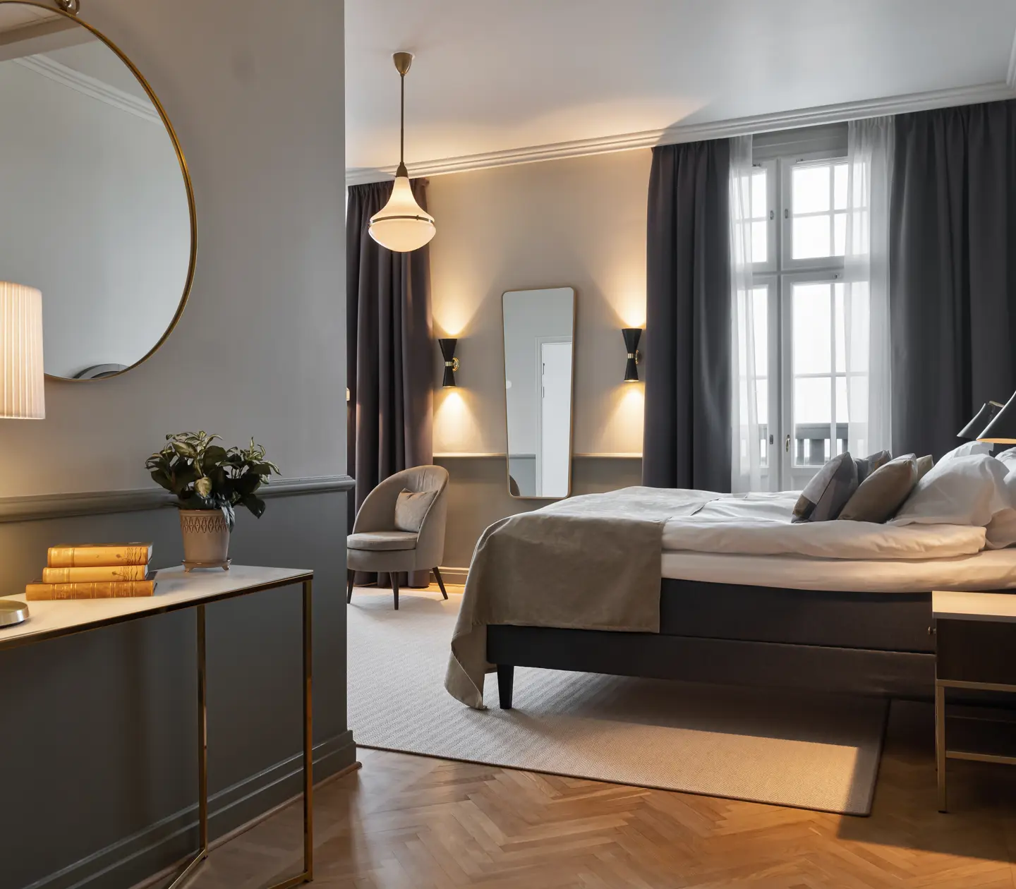 Cozy hotel room with double bed, armchairs, mirror and window