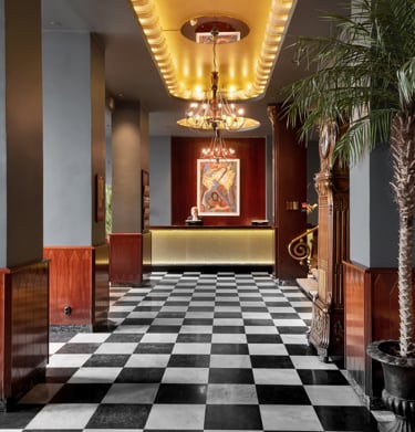 Hotellreception med rutigt golv och palm