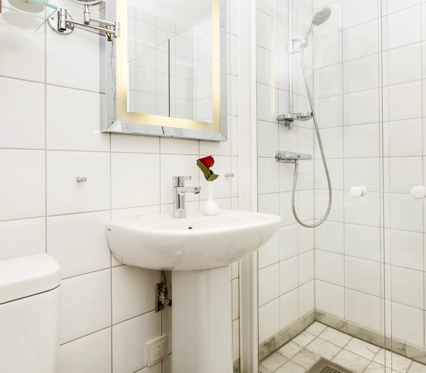 White bathroom with shower, sink and mirror