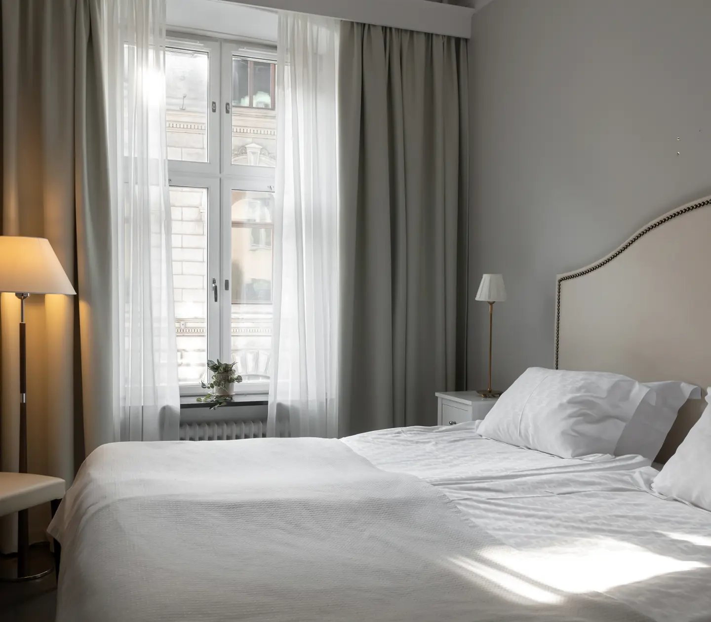 Cozy hotel room with double bed, floor lamp and window