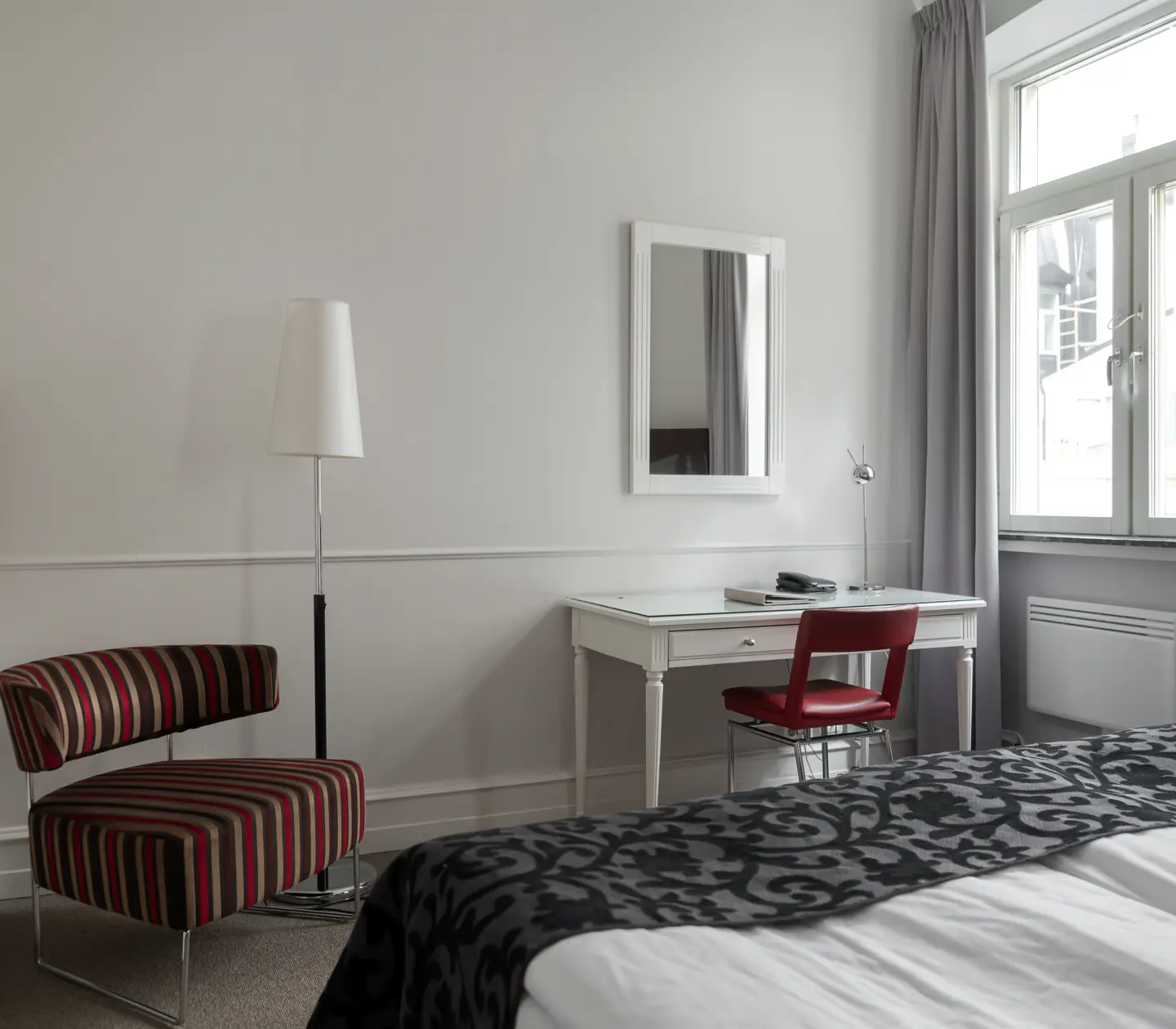 Hotel room with desk, armchair and mirror