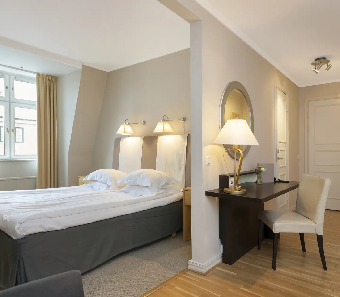 Bright hotel room with double bed, desk and window