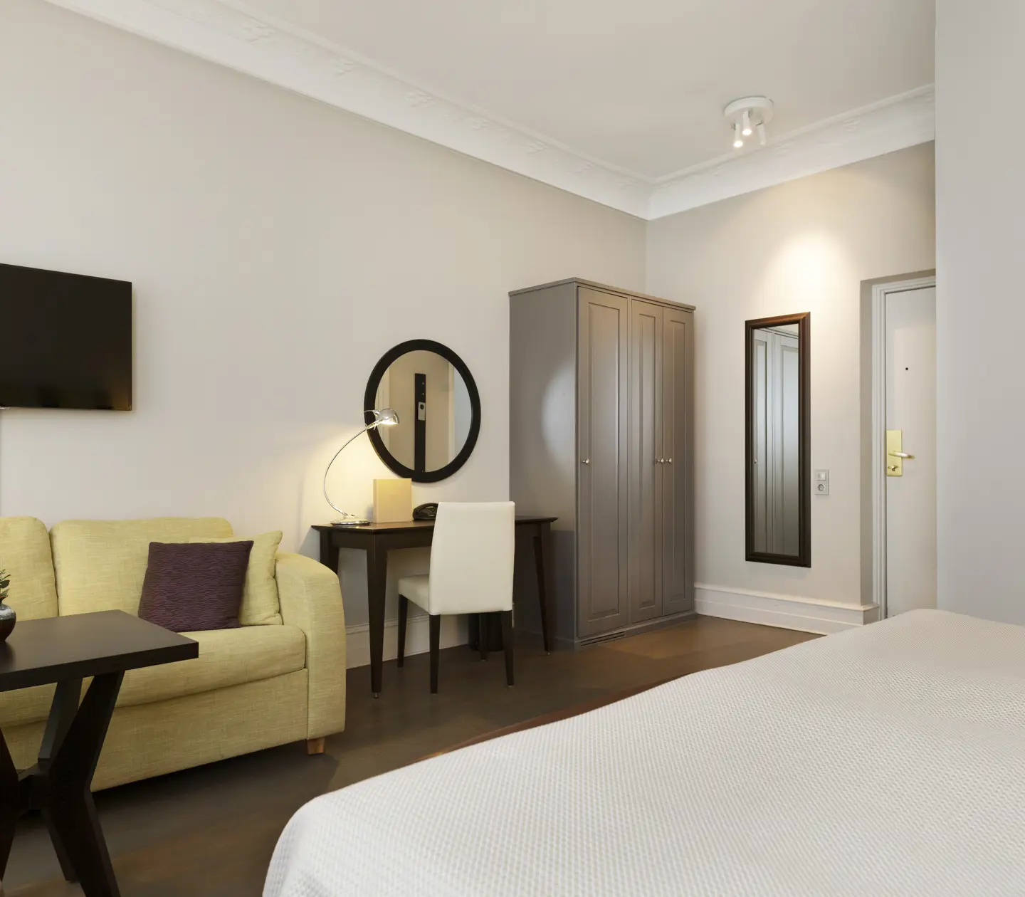 Hotel room with sofa, desk and wardrobe