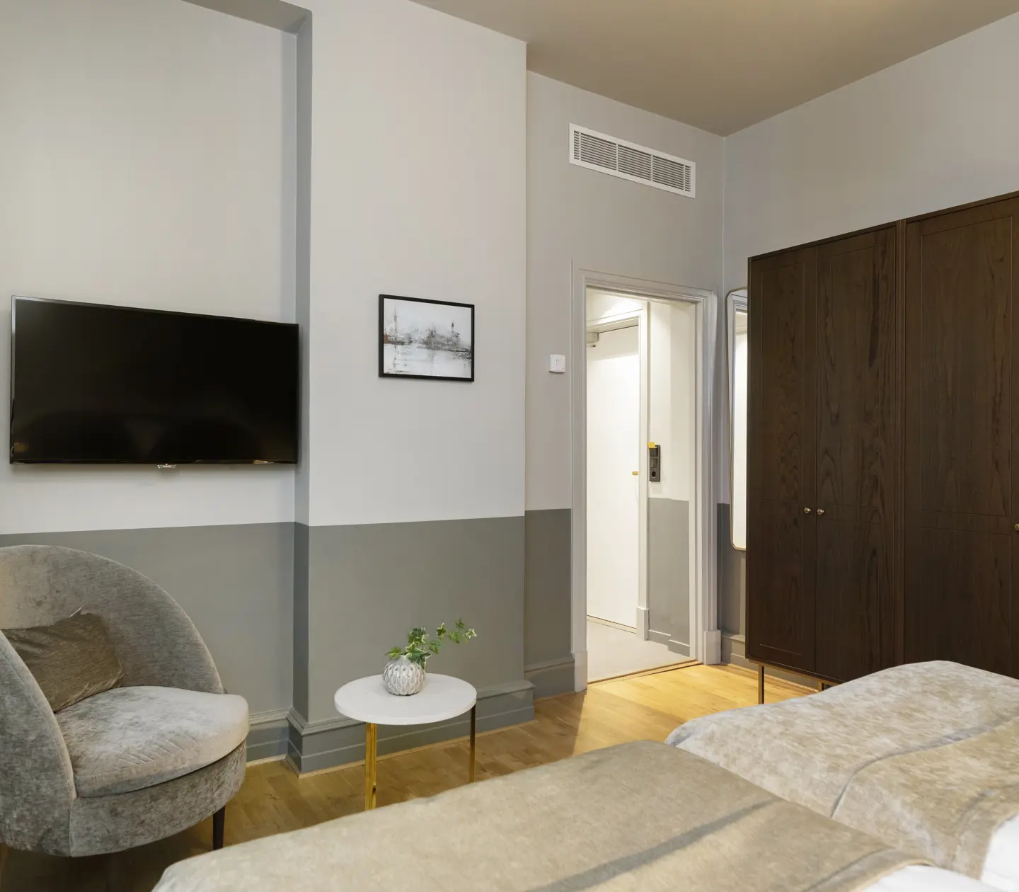 Hotel room with wardrobe, armchair and TV