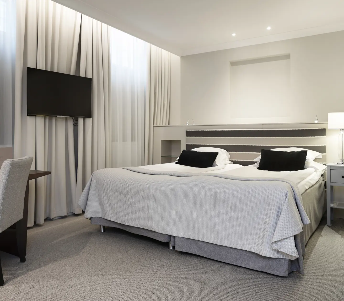 Hotel room with double bed, desk and TV