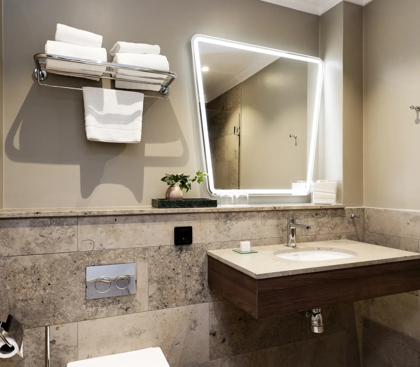 Beige bathroom with sink, mirror and towels